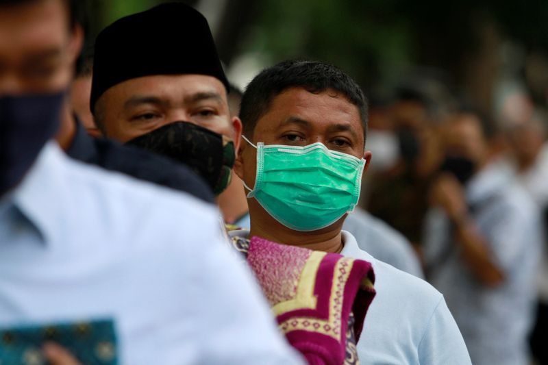 FILE PHOTO: Indonesia Muslims wearing protective face masks stand in