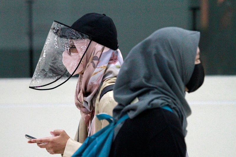 Women are pictured wearing a protective face mask and face