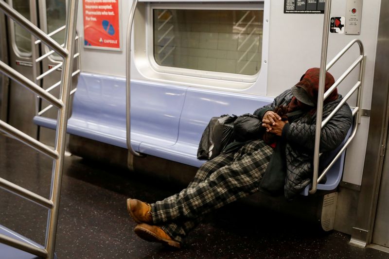 FILE PHOTO: A passenger sleeps inside an MTA subway car,