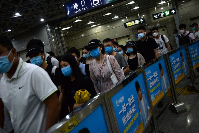 People wearing face masks commute inside a subway station during