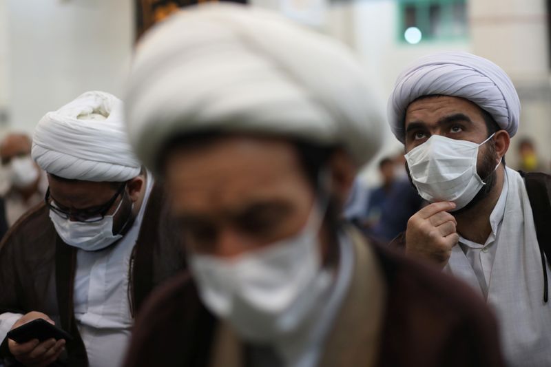 FILE PHOTO:  Iranian clerics wearing protective face masks attend