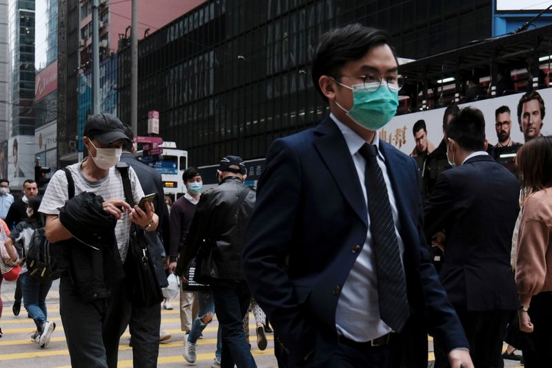 FILE PHOTO: People wear protective face masks as they take