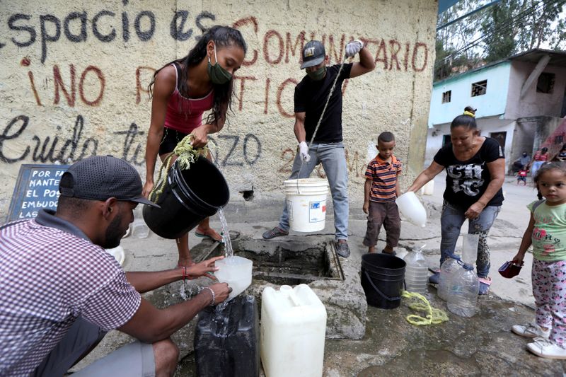 FILE PHOTO: People extract water from an unknown source in