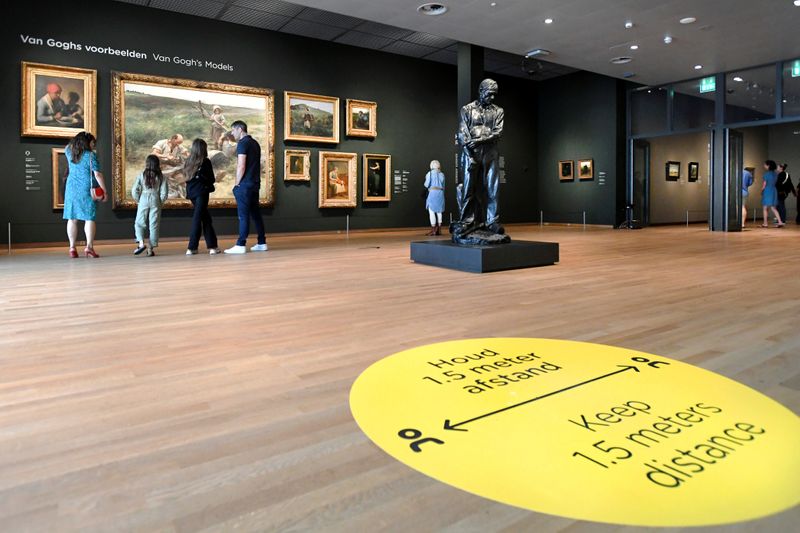 People look at paintings in the Van Gogh Museum that