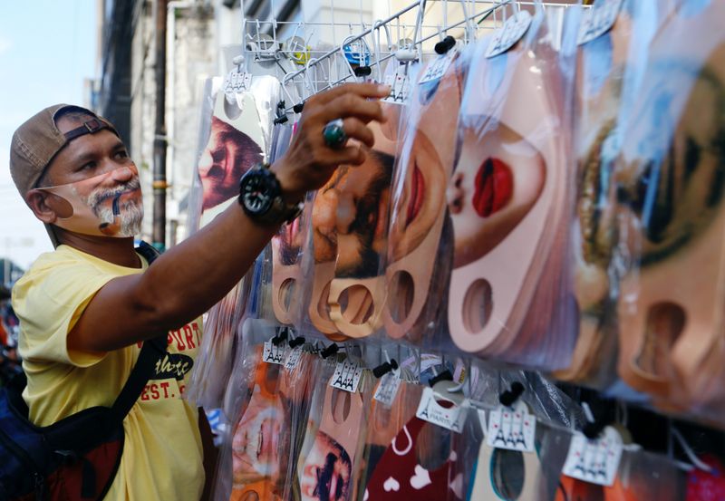 A vendor sells face design masks at a traditional market