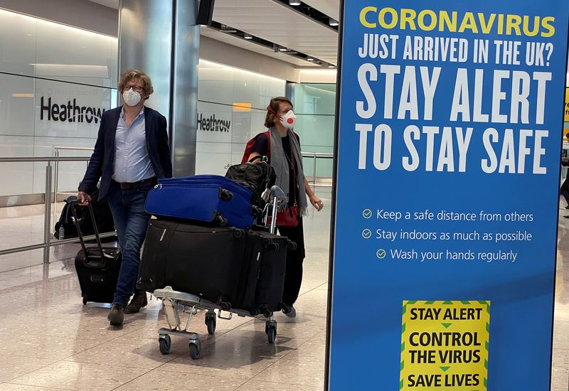 Passengers arrive at Heathrow Airport, as Britain launches its 14-day
