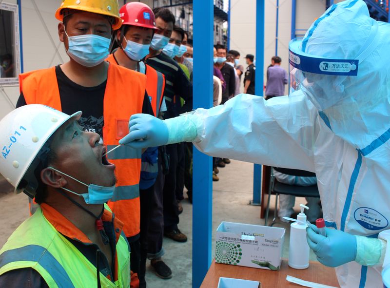 Medical worker collects swabs from construction workers for nucleic acid