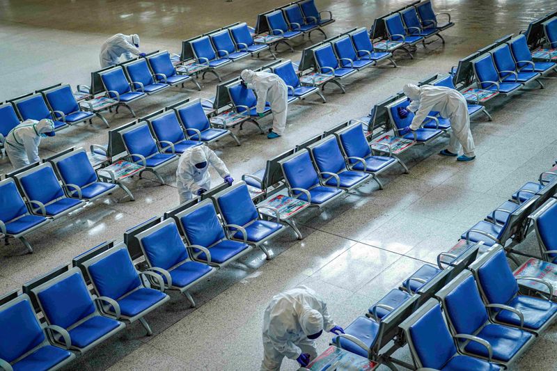 FILE PHOTO: Workers in protective suits disinfect a waiting hall