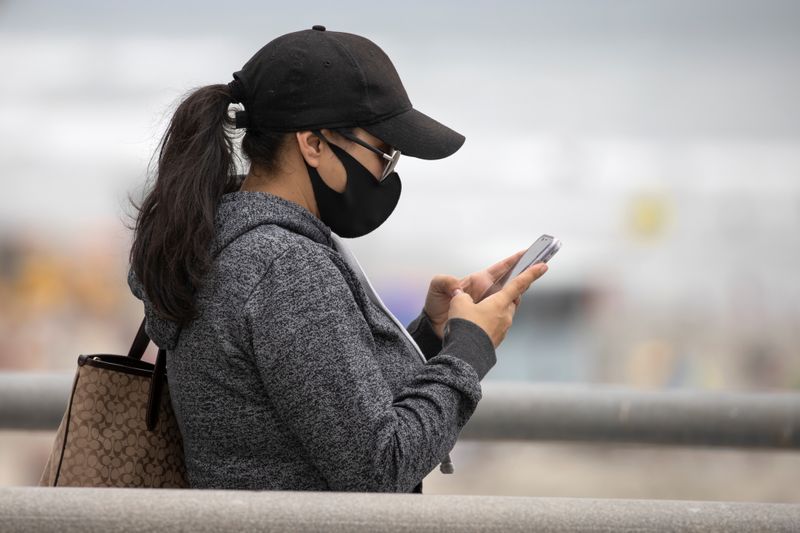 FILE PHOTO: A women wears a face masks as she