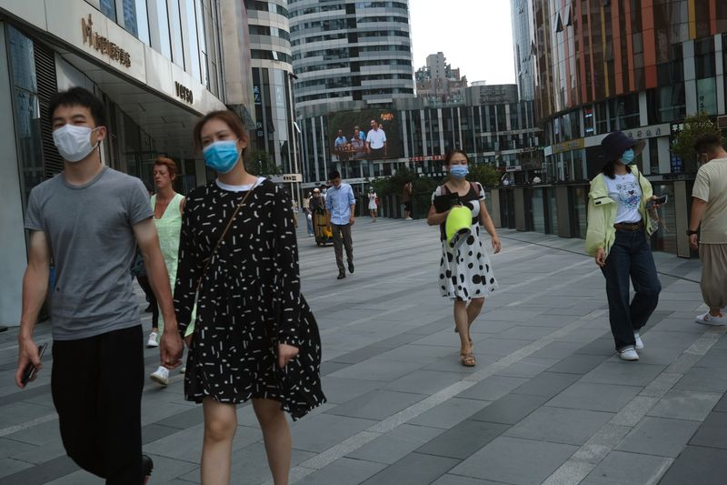 People wearing face masks are seen at the Sanlitun shopping