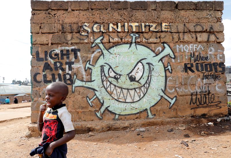 FILE PHOTO: A boy stands in front of a graffiti