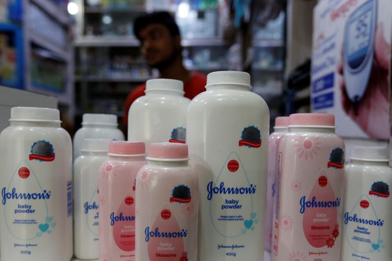 A worker waits for customers as bottles of Johnson &