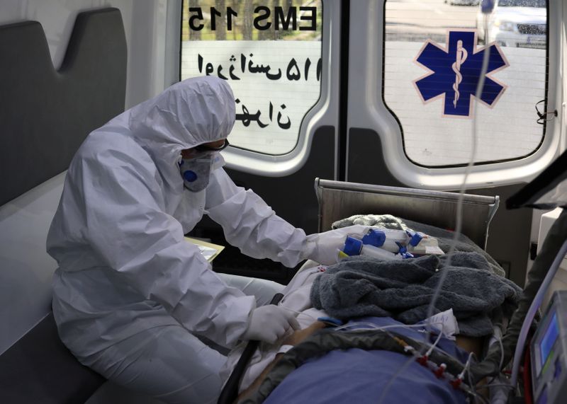 A member of emergency medical staff wearing protective suit, sits