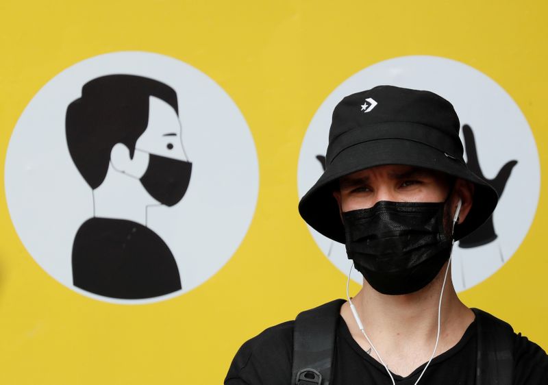 FILE PHOTO: A man wearing a protective face mask stands