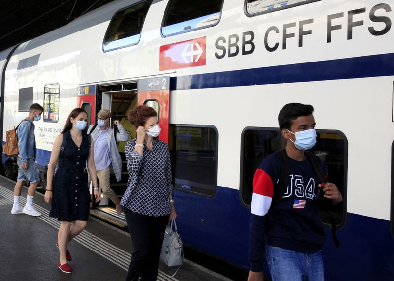 FILE PHOTO: Passengers wear protective masks as they leave a