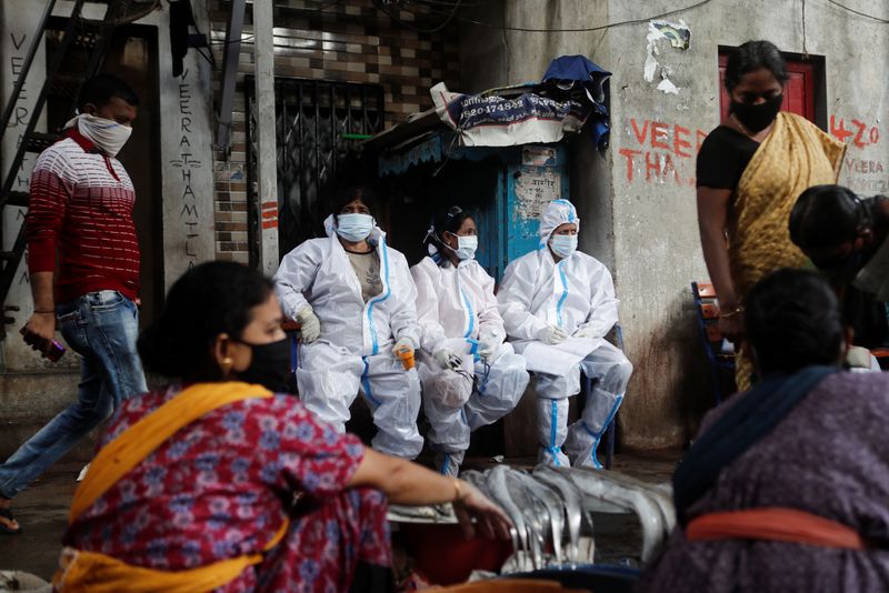 Health workers in personal protective equipment rest during a check