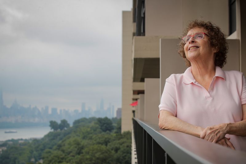 Laura Gross looks out from her balcony in Fort Lee,