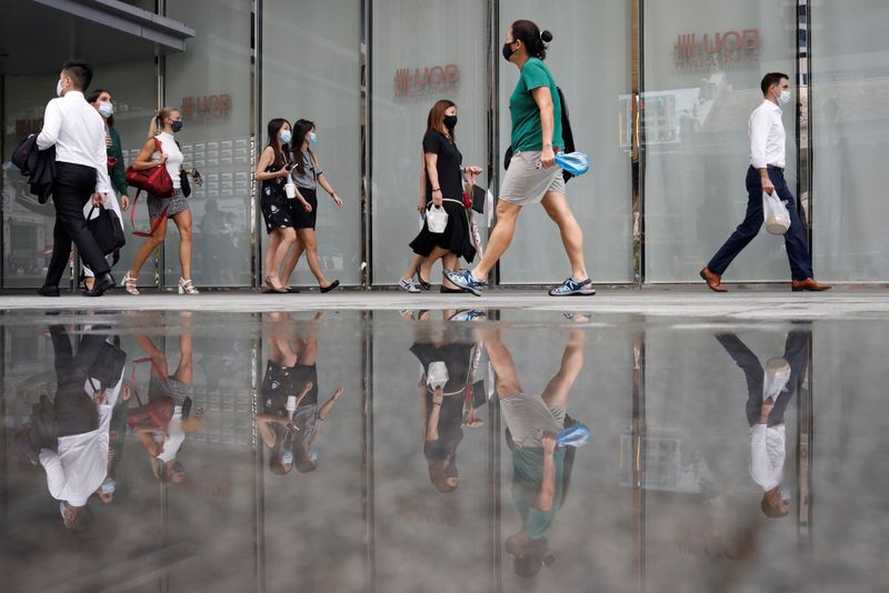 Office workers wearing protective face masks walk in Singapore’s central
