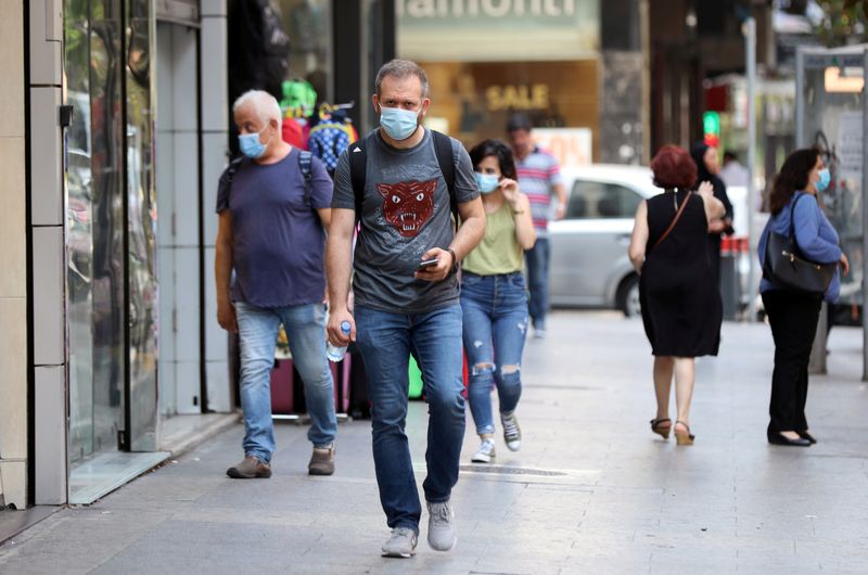 People walk as they wear face masks to prevent the