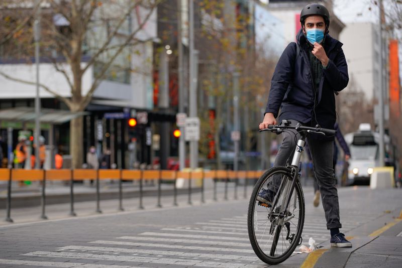 FILE PHOTO: A cyclist adjusts his protective face mask in