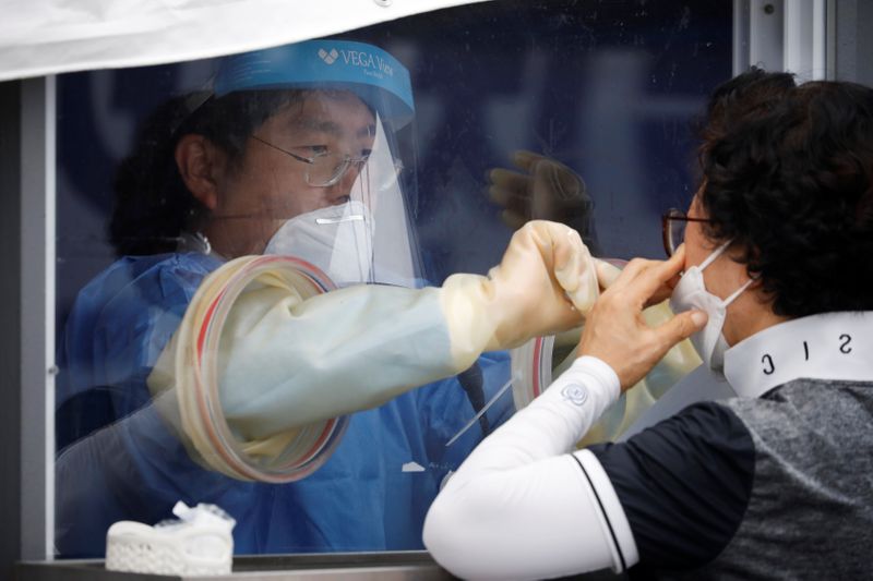 FILE PHOTO: A woman undergoes a coronavirus disease (COVID-19) test