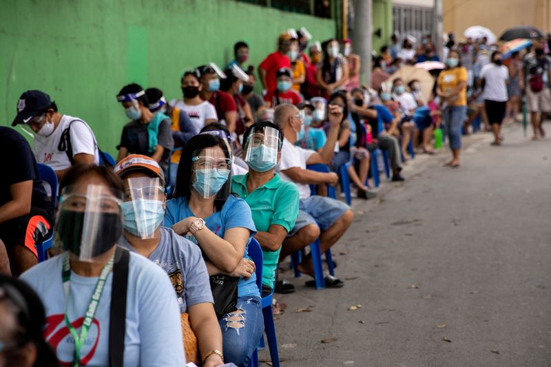 FILE PHOTO: Filipinos queue for government aid amid the coronavirus