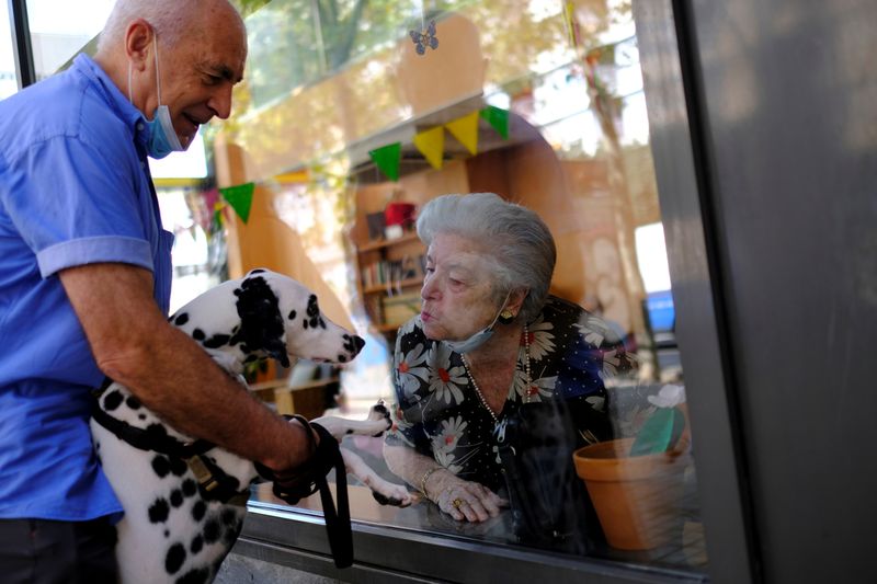 Elderly people get love through nursing home glass front as
