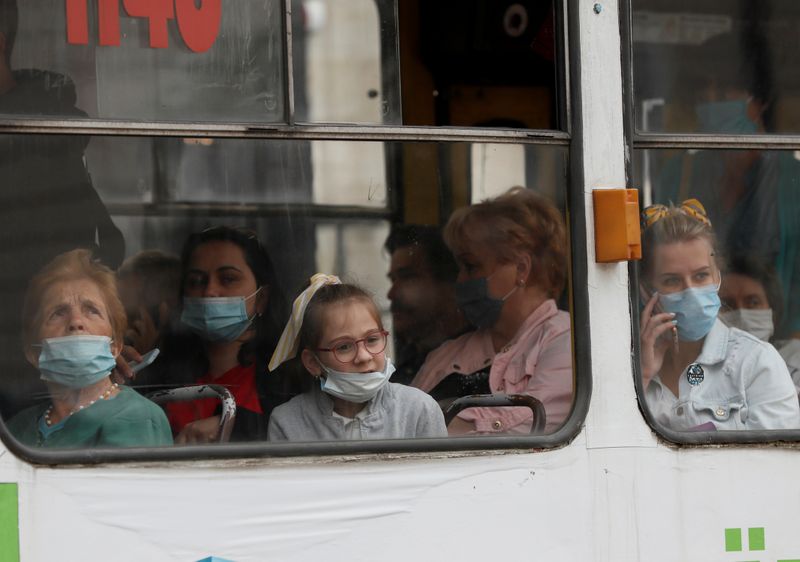 Passengers wearing protective face masks are seen in a tram