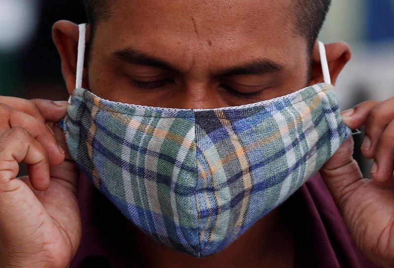 FILE PHOTO: A migrant worker puts on a mask at