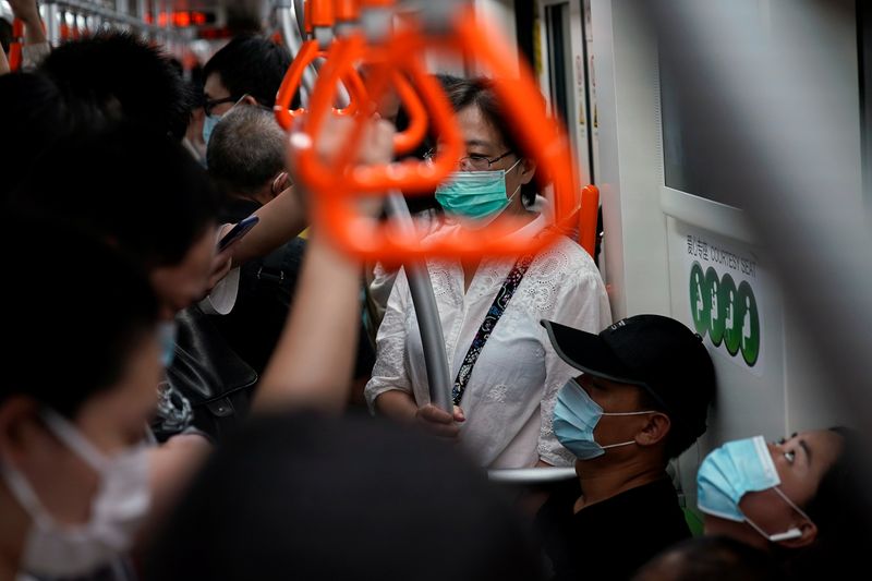 People wearing face masks are seen in a subway car,