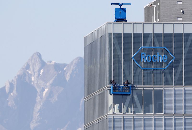 FILE PHOTO: Workers clean windows of a building of Roche