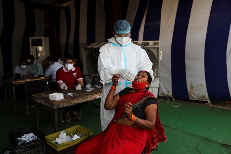 Health worker collects a swab sample from a woman at