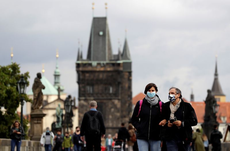 FILE PHOTO: People wearing face masks walk in Prague
