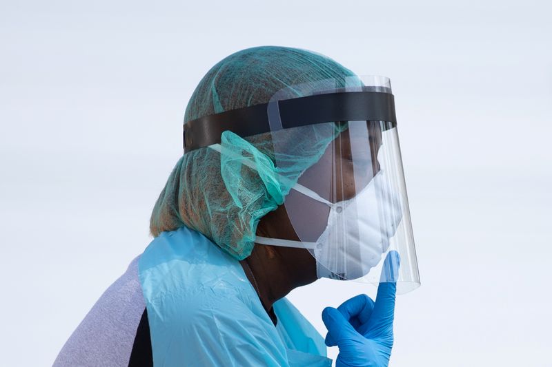 FILE PHOTO: Healthcare worker points towards her mask at COVID-19