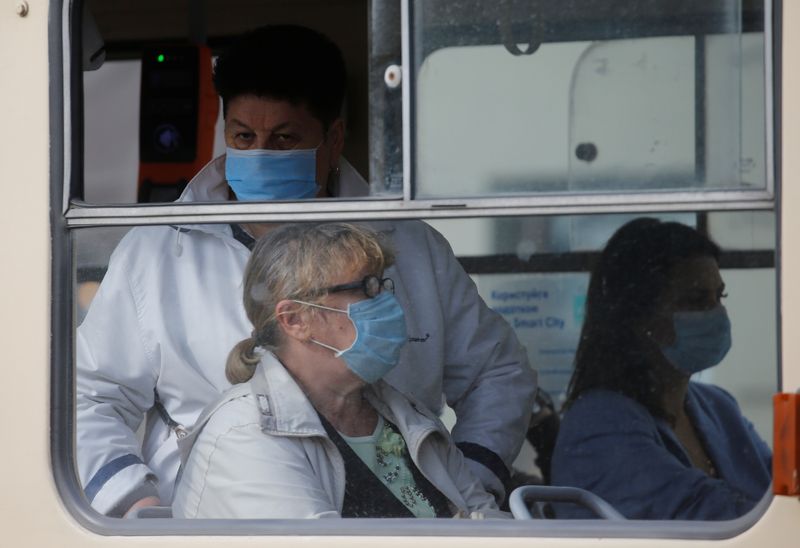 Passengers wearing protective face masks are seen inside a tram