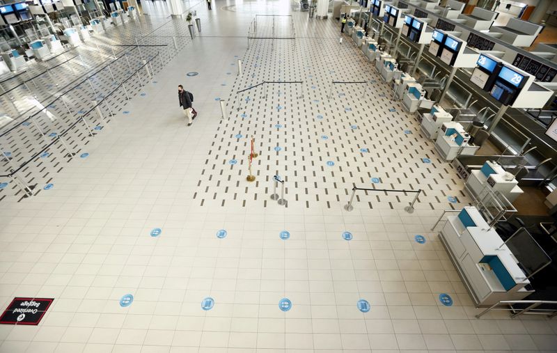 FILE PHOTO: A passenger walks past empty check-in counters at