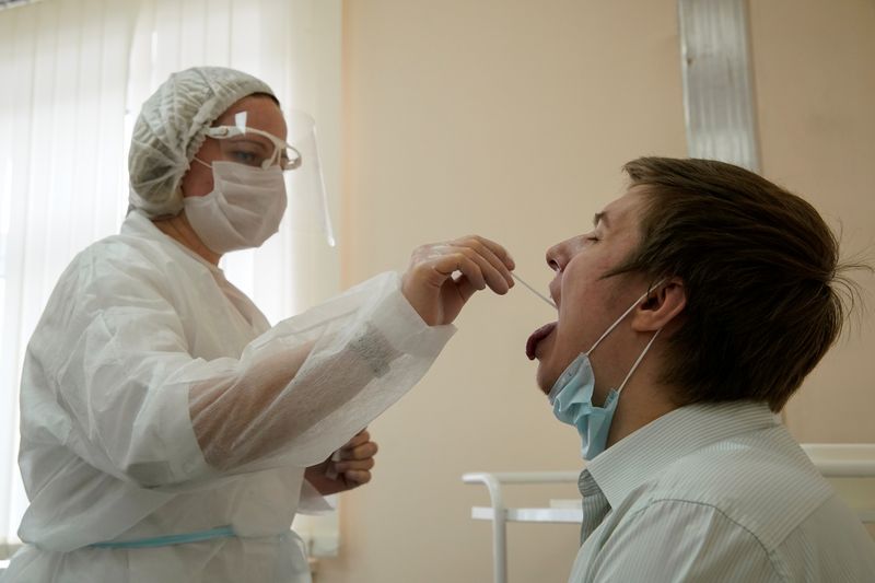 A health worker takes a swab from a man to