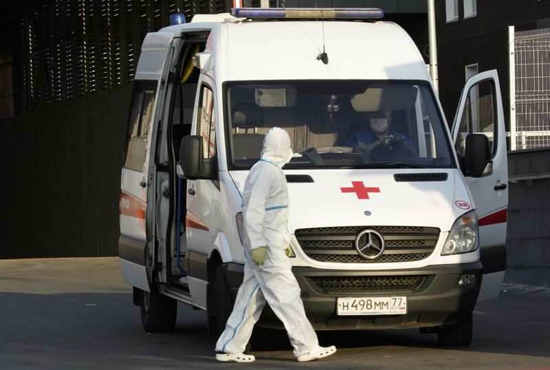A medical specialist walks next to an ambulance outside a
