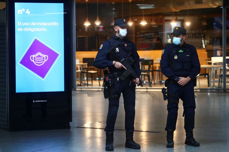 Spanish National Police officers wearing protective face masks stand guard