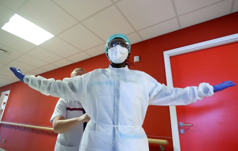 A member of medical personnel gets dressed in a protective