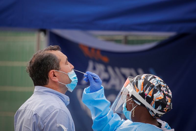 A health worker takes a swab sample from a man