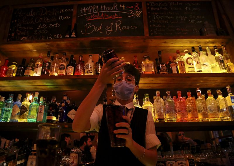 FILE PHOTO: A female bartender wearing a protective face mask