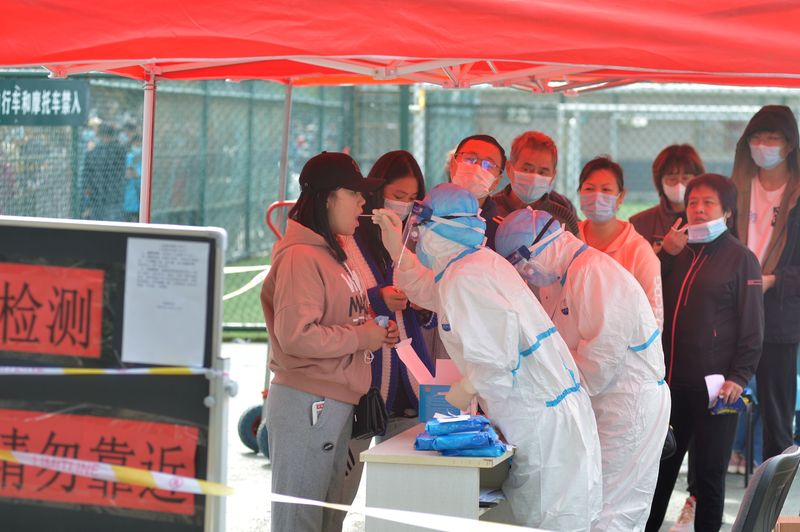 Medical workers in protective suits collect swabs for nucleic acid