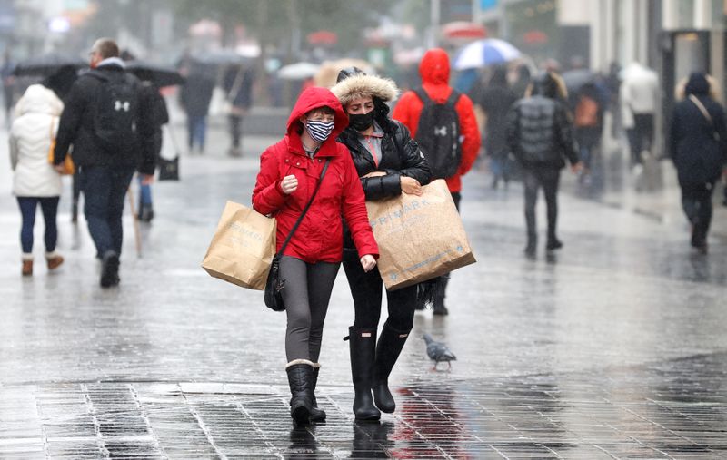 Women wearing face masks carry shopping bags in Liverpool