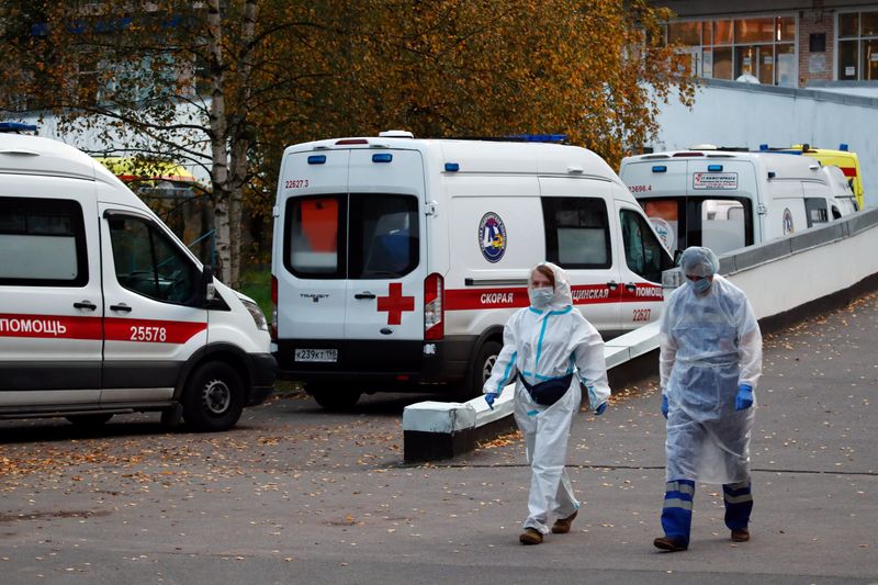 FILE PHOTO: Medical specialists walk next to ambulances near the