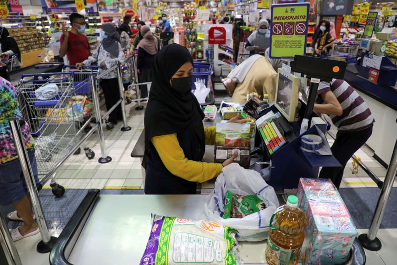 People line up to pay at a supermarket in Subang