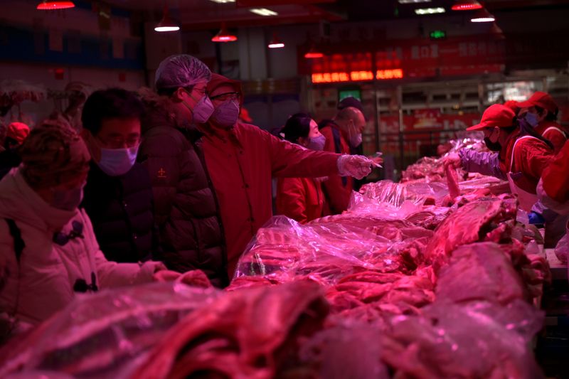 FILE PHOTO: Customers wearing face masks buy pork meat at