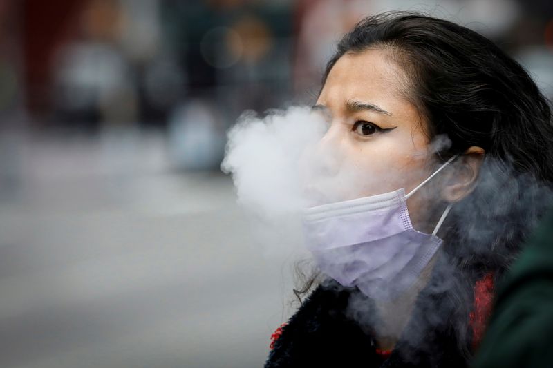 FILE PHOTO: A woman exhales after vaping in Times Square,