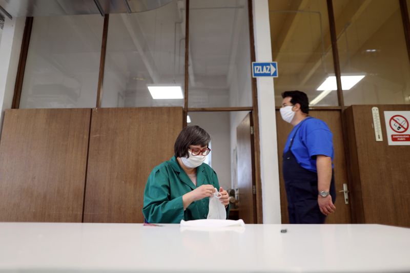 A woman inspects protective face masks in factory DES in