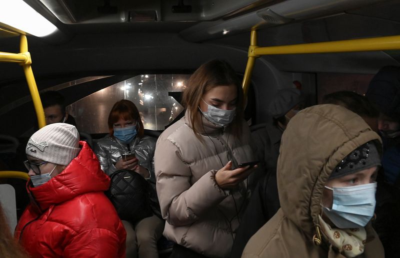 Passengers use protective face masks inside a bus in Omsk